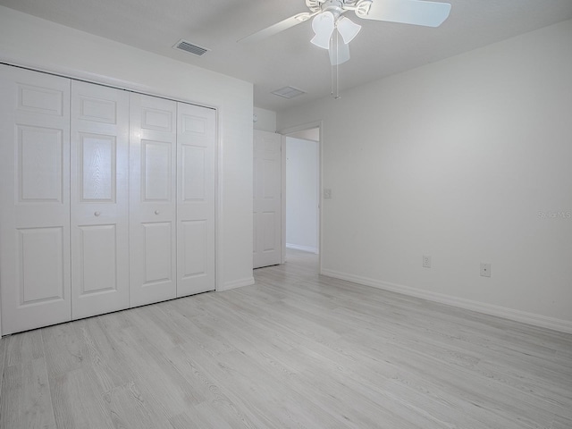 unfurnished bedroom featuring baseboards, visible vents, ceiling fan, wood finished floors, and a closet