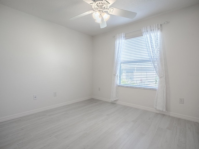 unfurnished room with light wood-style floors, baseboards, and a ceiling fan