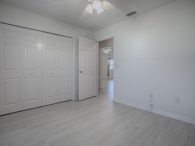 unfurnished bedroom with light wood-type flooring, baseboards, visible vents, and a closet