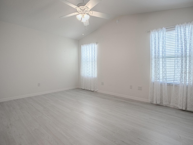 spare room featuring a healthy amount of sunlight, light wood finished floors, a ceiling fan, and lofted ceiling