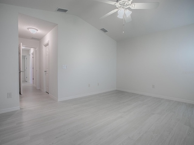 spare room featuring light wood finished floors, visible vents, and baseboards