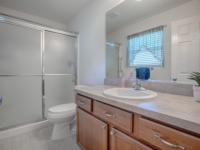 full bath featuring toilet, a stall shower, vanity, and visible vents