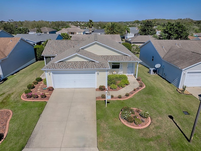 view of front of home with a garage, driveway, roof with shingles, a residential view, and a front lawn