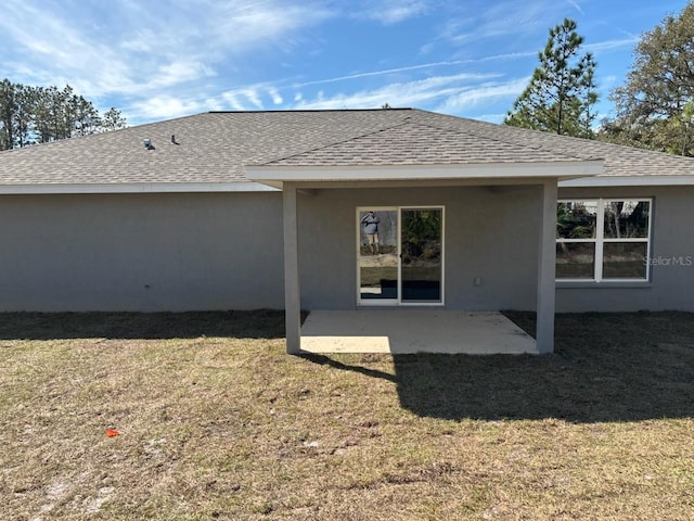 back of property featuring a patio, a lawn, and roof with shingles