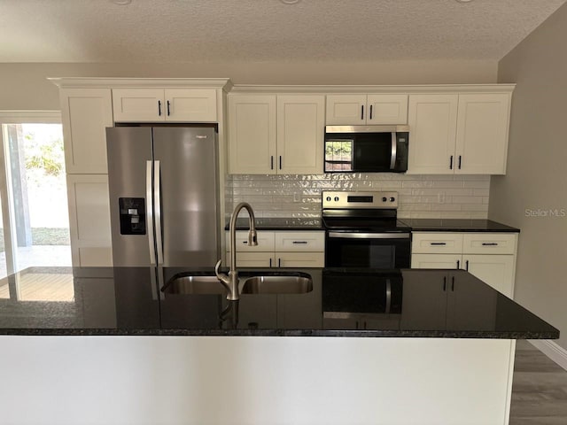 kitchen with white cabinetry, appliances with stainless steel finishes, tasteful backsplash, and a sink