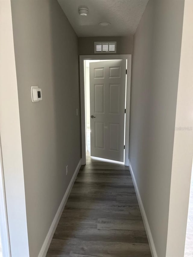 entryway with a textured ceiling, baseboards, and dark wood-style flooring