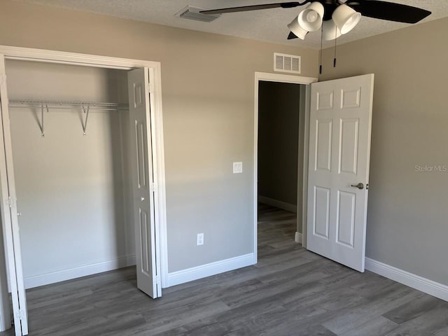 unfurnished bedroom with baseboards, a closet, visible vents, and wood finished floors