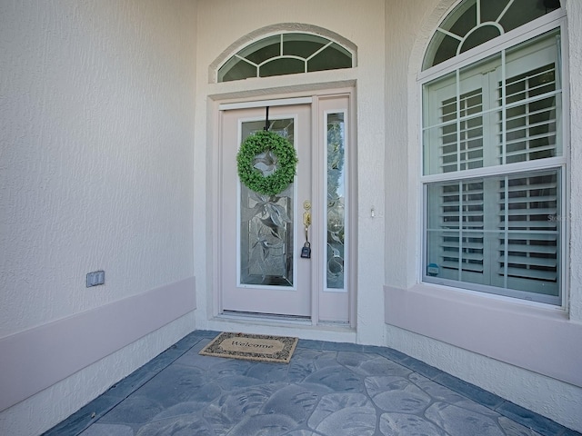 doorway to property featuring stucco siding