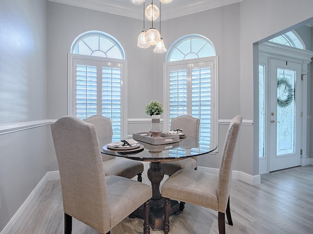 dining area featuring ornamental molding, plenty of natural light, wood finished floors, and baseboards