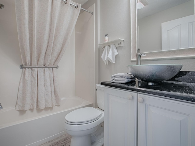 full bathroom with toilet, shower / bathtub combination with curtain, wood finished floors, and vanity