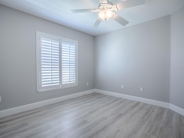 unfurnished room with light wood-type flooring, baseboards, and a ceiling fan