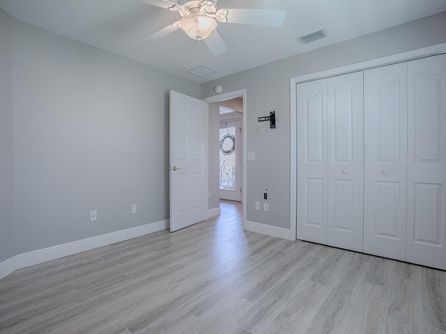 unfurnished bedroom featuring ceiling fan, visible vents, baseboards, a closet, and light wood finished floors