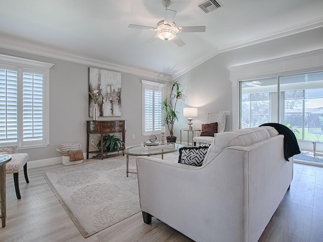 living room with crown molding, visible vents, a ceiling fan, vaulted ceiling, and baseboards