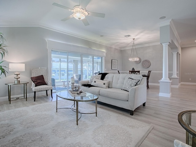 living area with decorative columns, ornamental molding, light wood-style flooring, and baseboards