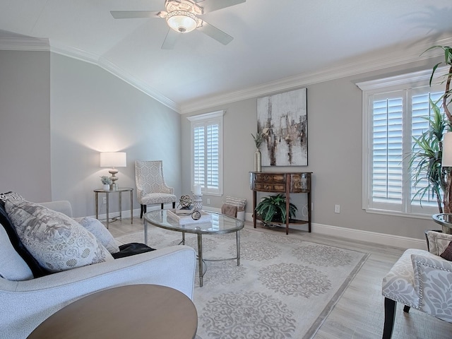 living area featuring lofted ceiling, light wood-type flooring, ornamental molding, and ceiling fan