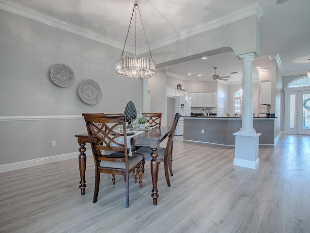 dining room with crown molding, ornate columns, light wood-style flooring, a ceiling fan, and baseboards