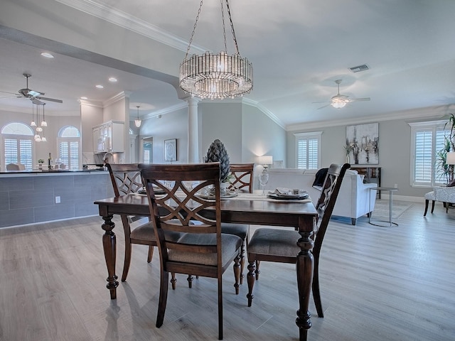 dining room featuring ceiling fan, decorative columns, light wood-style flooring, and crown molding