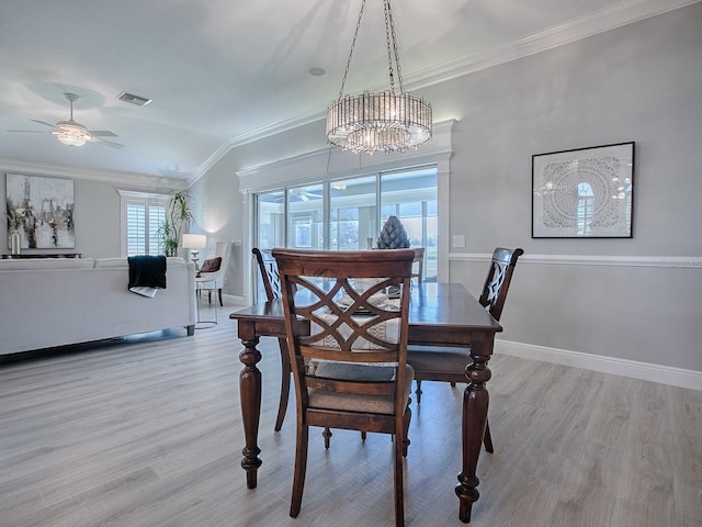 dining area with light wood finished floors, baseboards, visible vents, and crown molding