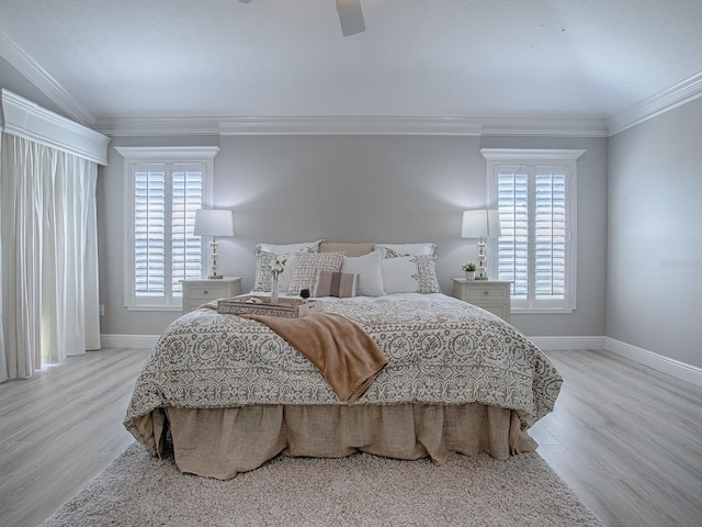 bedroom with baseboards, light wood finished floors, multiple windows, and crown molding