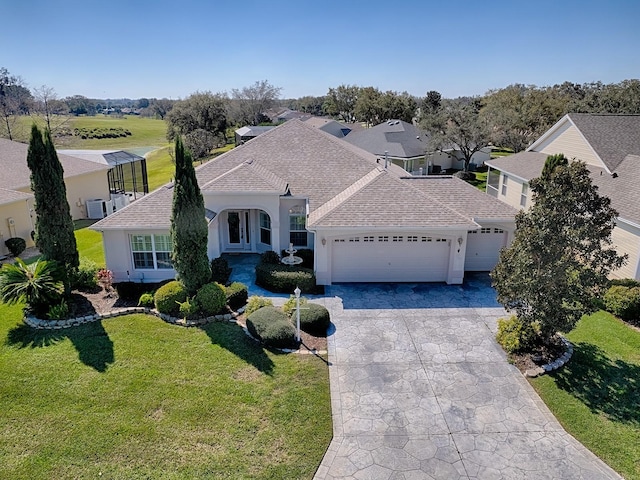 view of front of home with roof with shingles, stucco siding, a garage, driveway, and a front lawn