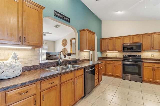 kitchen featuring appliances with stainless steel finishes, dark countertops, a sink, and visible vents