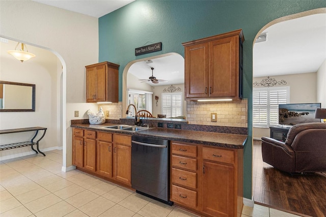 kitchen featuring visible vents, arched walkways, dishwasher, open floor plan, and a sink