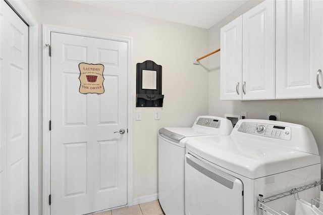 laundry room with washer and dryer, cabinet space, baseboards, and light tile patterned floors