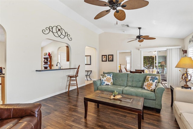 living area featuring baseboards, visible vents, arched walkways, wood finished floors, and vaulted ceiling