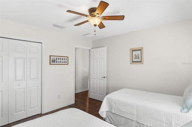 bedroom featuring baseboards, visible vents, ceiling fan, wood finished floors, and a closet