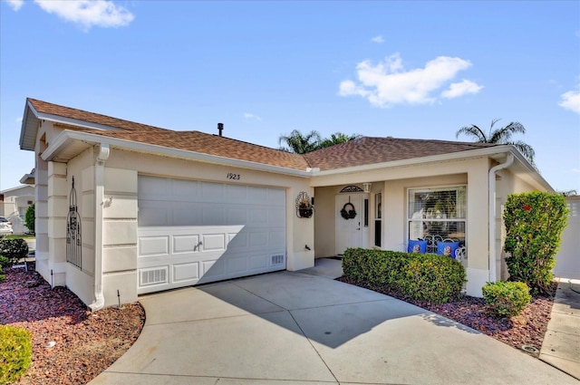 single story home with an attached garage, roof with shingles, concrete driveway, and stucco siding