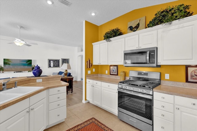 1923 Greeleyville Ter, The Villages, FL 32162 - kitchen featuring a textured ceiling, light tile patterned flooring, a sink, open floor plan, and appliances with stainless steel finishes