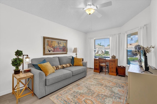 1923 Greeleyville Ter, The Villages, FL 32162 - living room with light wood-type flooring, ceiling fan, baseboards, and a textured ceiling