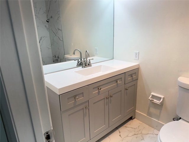 bathroom featuring toilet, marble finish floor, baseboards, and vanity