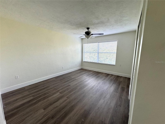 unfurnished room with dark wood-style floors, ceiling fan, baseboards, and a textured ceiling