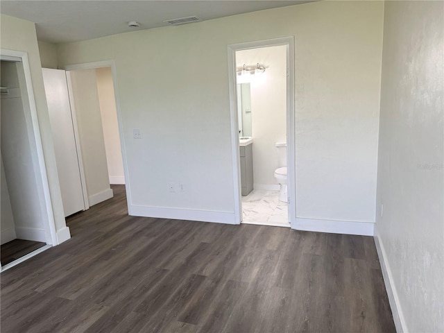 unfurnished bedroom featuring a closet, wood finished floors, visible vents, and baseboards