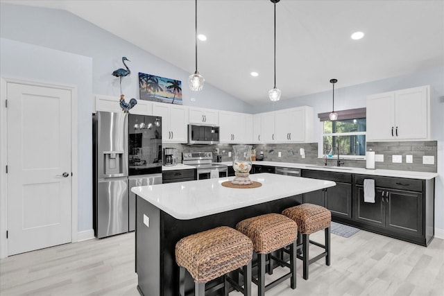 kitchen with stainless steel appliances, light countertops, white cabinets, and a sink