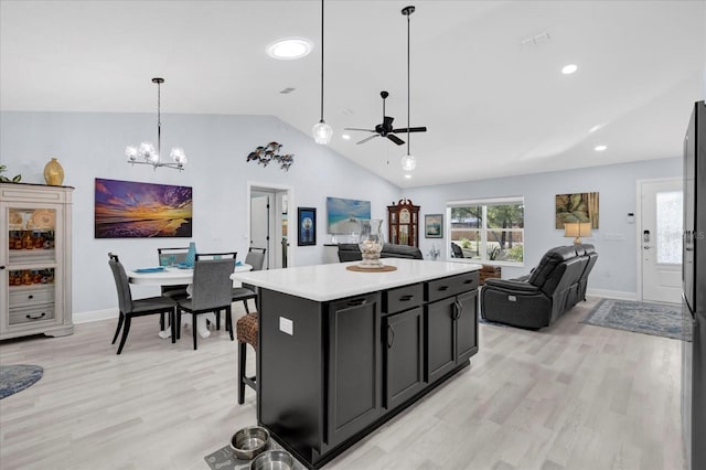 kitchen with a healthy amount of sunlight, open floor plan, dark cabinets, and light countertops