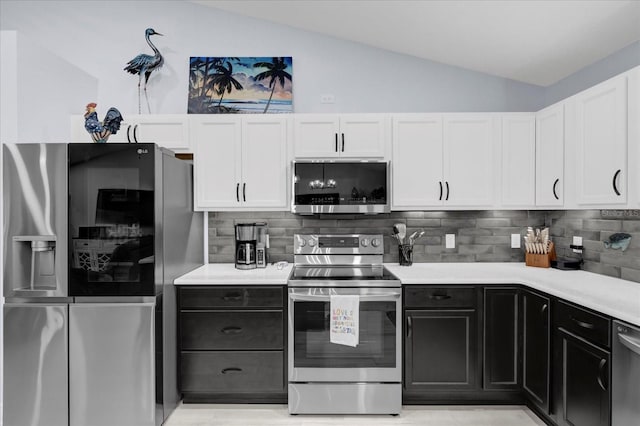 kitchen featuring white cabinetry, appliances with stainless steel finishes, vaulted ceiling, and light countertops