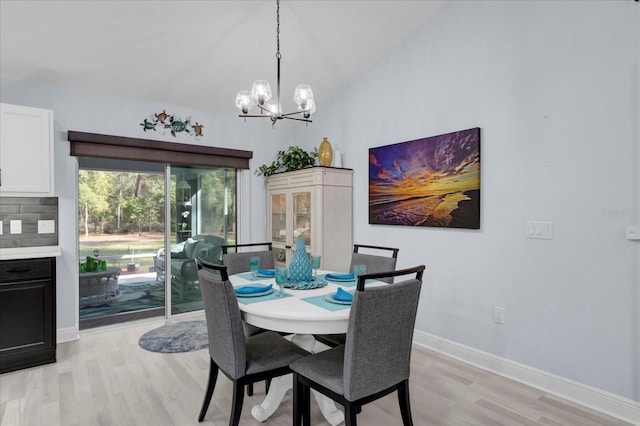 dining room with lofted ceiling, light wood-style floors, baseboards, and a notable chandelier