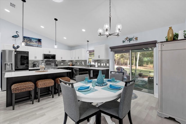 dining space with a notable chandelier, lofted ceiling, recessed lighting, visible vents, and light wood-style flooring