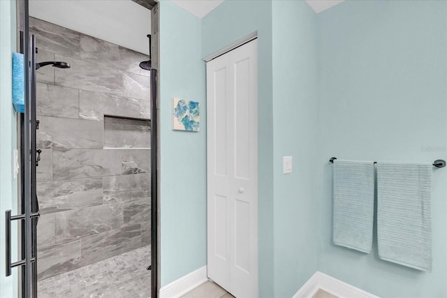 bathroom with a stall shower and baseboards