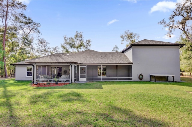 back of property featuring a yard, a sunroom, and stucco siding