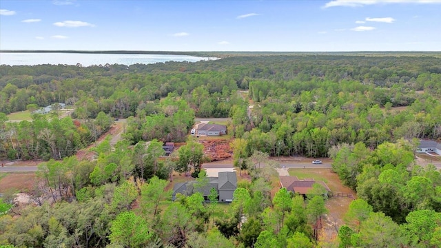 drone / aerial view with a forest view and a water view