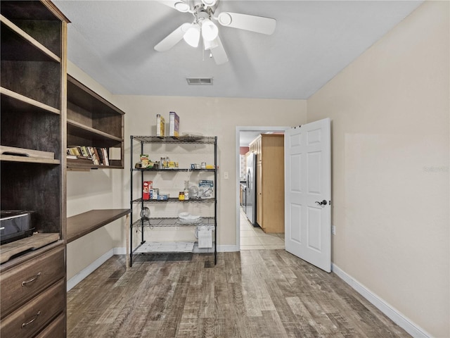 interior space with baseboards, visible vents, wood finished floors, and freestanding refrigerator