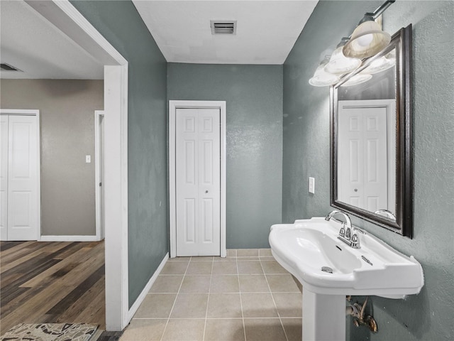 bathroom with baseboards, visible vents, and tile patterned flooring