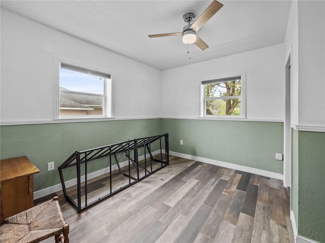 bedroom featuring ceiling fan, baseboards, and wood finished floors