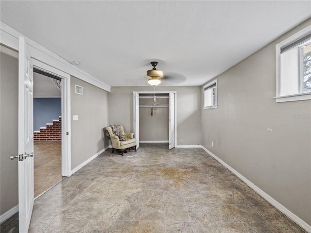 unfurnished room featuring a ceiling fan, baseboards, visible vents, and a wealth of natural light