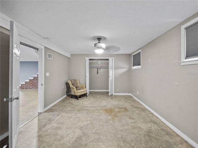 unfurnished room with baseboards, visible vents, and a ceiling fan