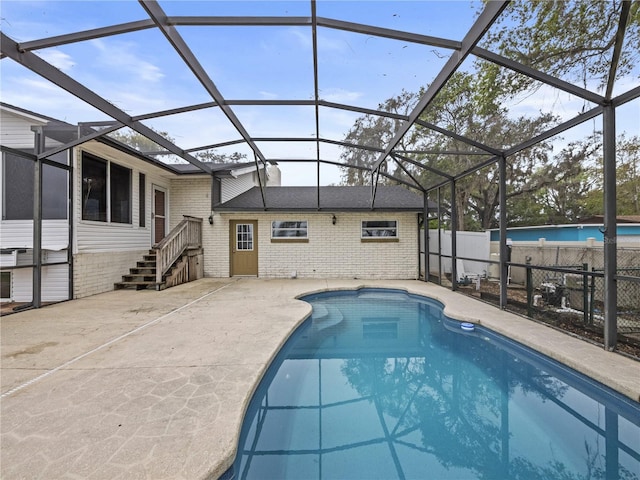 view of swimming pool with a patio, fence, a fenced in pool, and a lanai