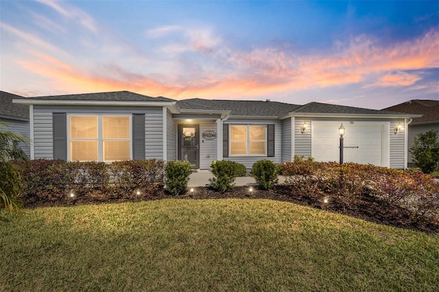 ranch-style house featuring a garage and a front lawn